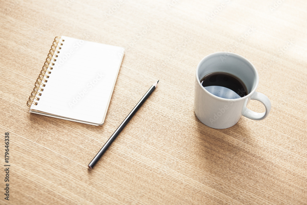 note, pencil, coffee on the wood table at the daylight.
