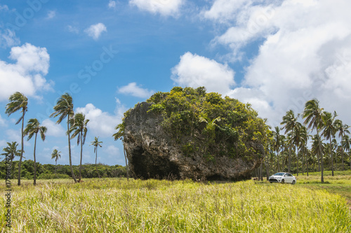 Car stands next to Tsunami Rock, Tongatapu, Tonga photo