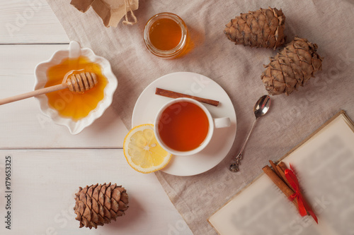 cup of hot black tea, lemon, homemade cookies and honey on white rustic wooden background. Breakfast concept. Top view, flat lay style