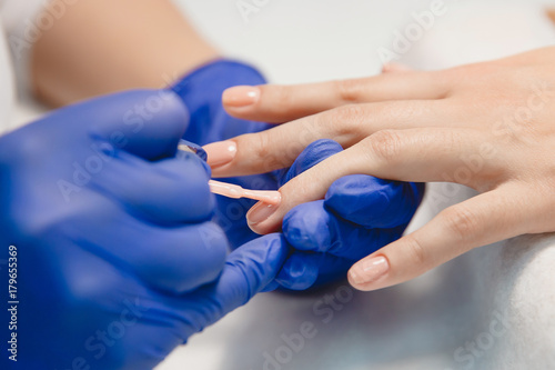 Manicure. Nails saloon woman applying nail polish