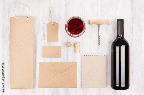 Corporate identity template for wine industry with bottle red wine and wineglass on soft white wood background. Mock up for branding, advertising, design, business presentations and portfolios. photo