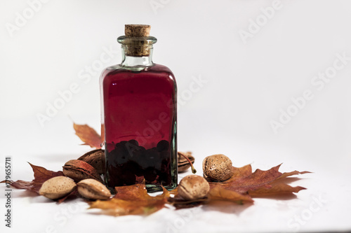 Autumn bodegon composed of liquor, grapes, almonds, pomegranate and dried leaves photo