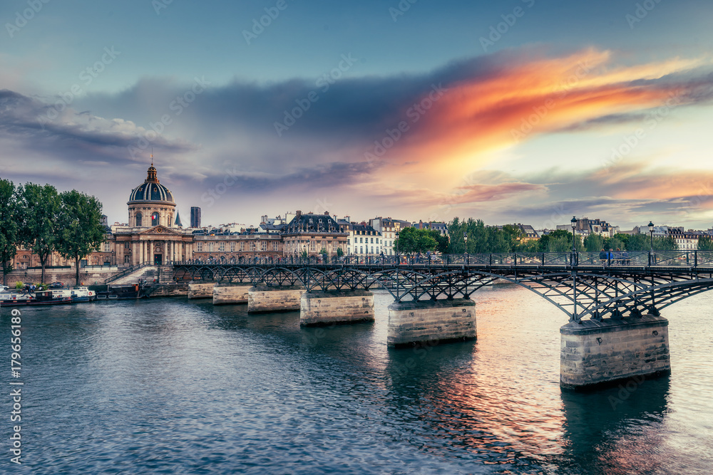 Famous Pont Neuf in Paris, France. Spectacular cityscape with dramatic sunset sky.