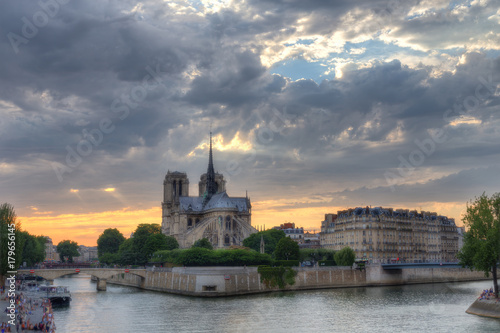 Notre Dame cathedral in Paris, France at dusk. Scenic skyline with dramatic sunset sky. Travel background.