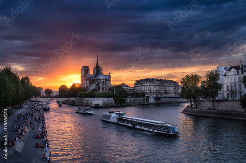 Notre Dame cathedral in Paris, France against sunset sky. Scenic skyline. Colourful travel background.