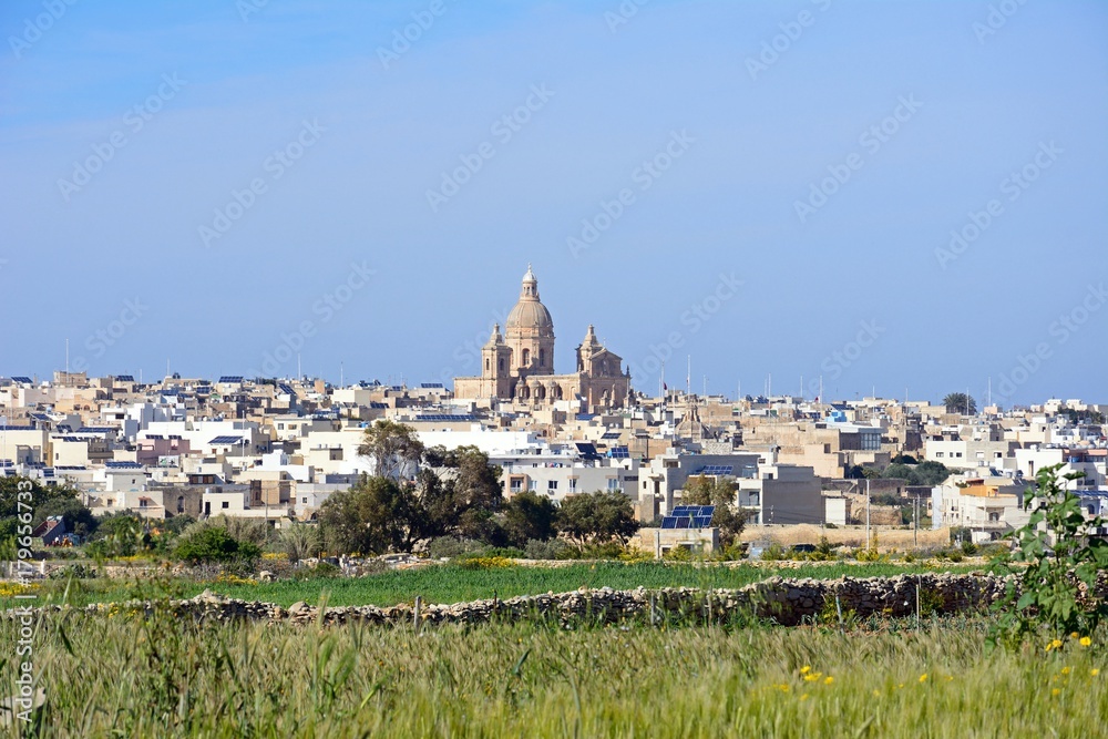 View across crop fields towards Siggiewi during the Springtime, Malta.