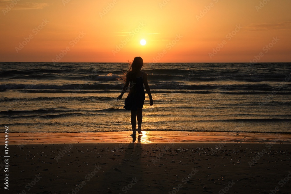 A little girl on the seaside sunset