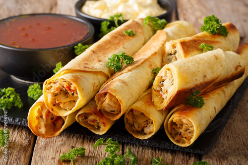 Baked taquitos with chicken and cheese close-up. horizontal photo