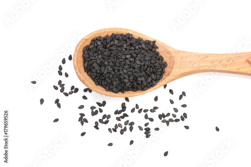 Black sesame seeds in a wooden spoon isolated on white background top view