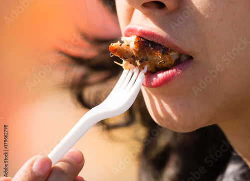 the girl eats meat in the nature