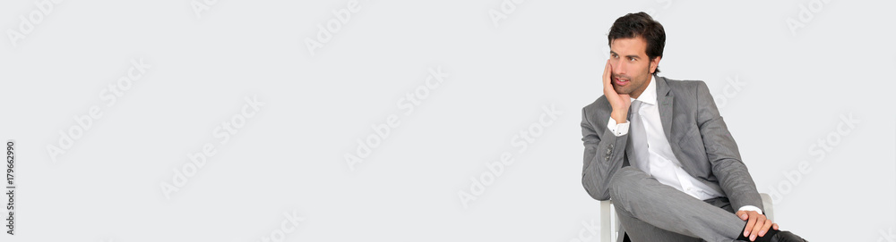Businessman sitting on chair on grey background - banner template web Businessman sitting on chair on grey background - banner template web