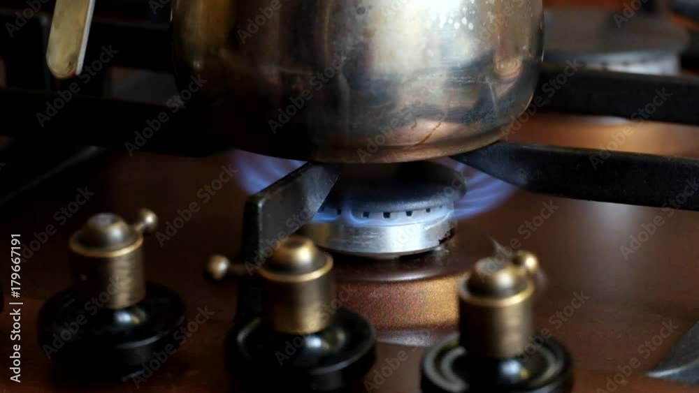 On the gas cooker is burning gas and someone puts the kettle on fire On the gas cooker is burning gas and someone puts the kettle on fire