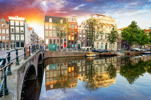 Beautiful Amsterdam sunset. Typical old dutch houses on the bridge and canals in spring, Netherlands