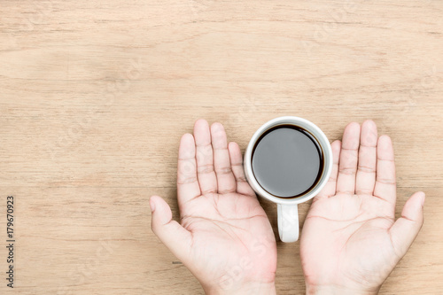 hand and coffee on table