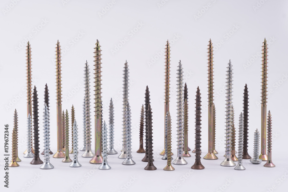 some screws of varying length arranged on a white plane like the skyline of a city some screws of varying length arranged on a white plane like the skyline of a city