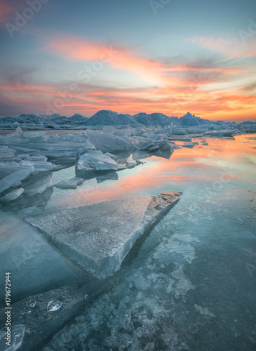 Frozen sea during sunset. Beautiful natural seascape in the winter time
