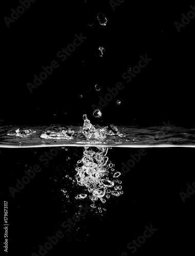 stream of bubbles under water on a black background