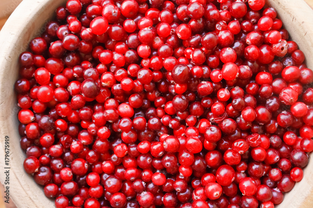 Red berries close-up. Top view of red berries in a wooden bowl Red berries close-up. Top view of red berries in a wooden bowl