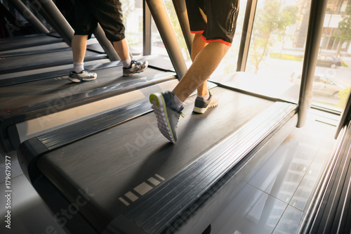 Machine treadmill with people running closeup at fitness gym