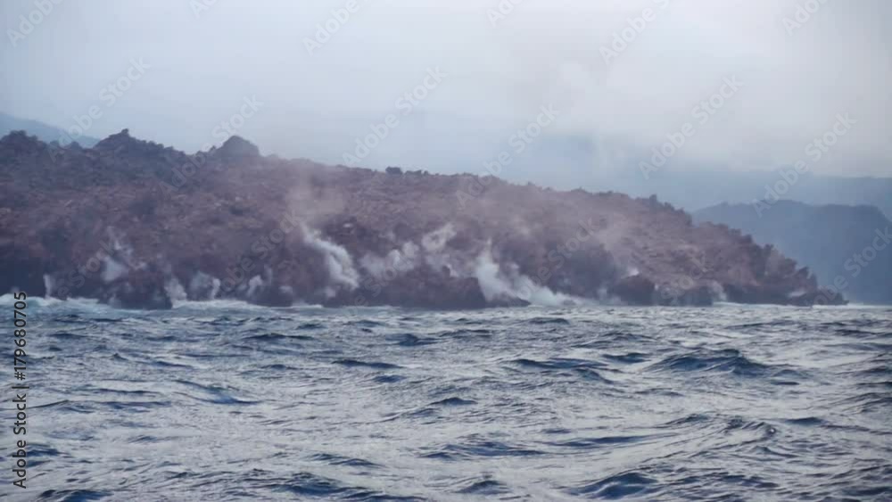 Okhotsk Sea, Chirpoy Island, Snow volcano activity, Russia. Hot volcanic lava falls into the sea. White fog rises over the shore.
Okhotsk Sea, Chirpoy Island, Snow volcano activity, Russia. Hot volcanic lava falls into the sea. White fog rises over the shore.