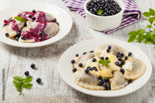 Delicious dumplings with fresh blueberries served with whipped cream and sugar or sauce.