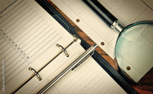 pen, magnifying glass and diary