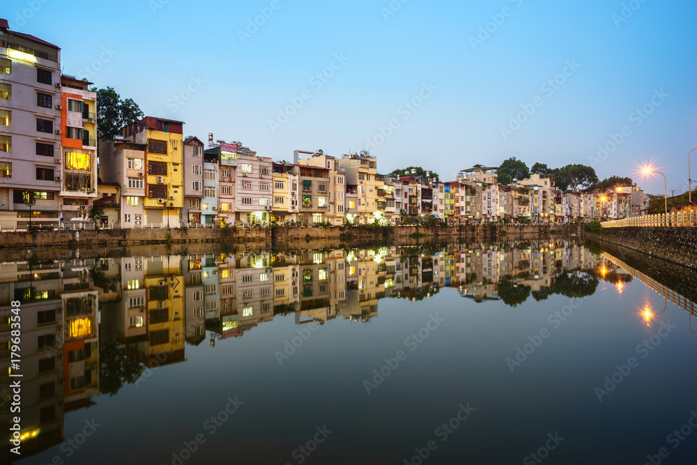 Resident houses and reflection on Tinh Bien lake in Hanoi, Vietnam