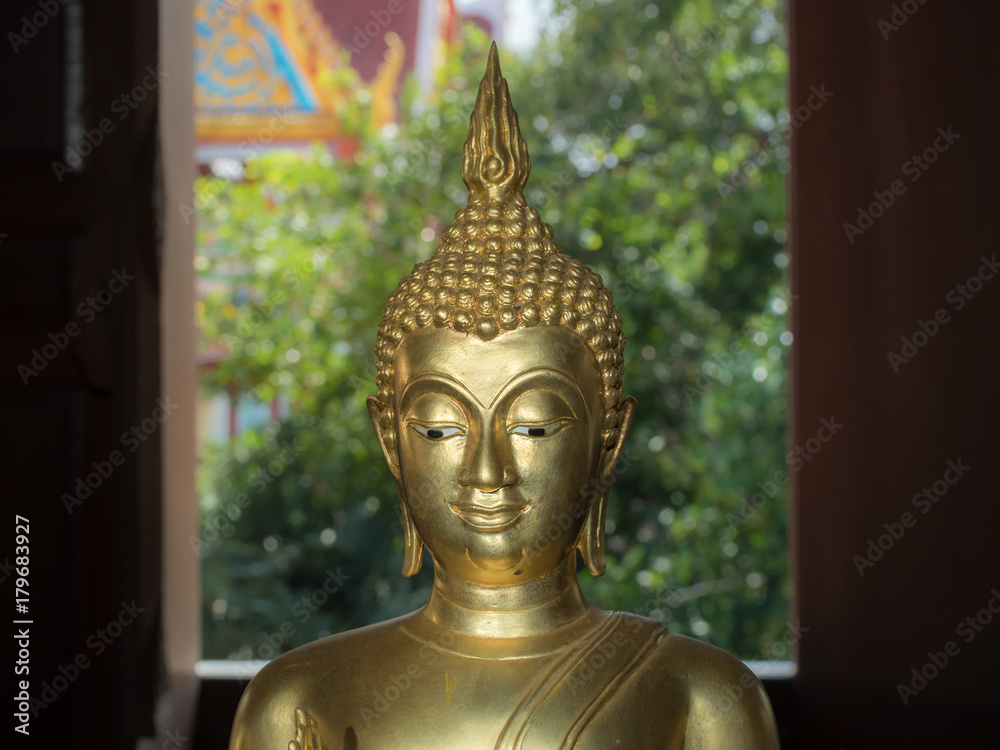 Buddha Face, Image of Buddha. Golden Buddha Statue, beautiful face of Buddha Image with peaceful eyes and smile closeup on background.