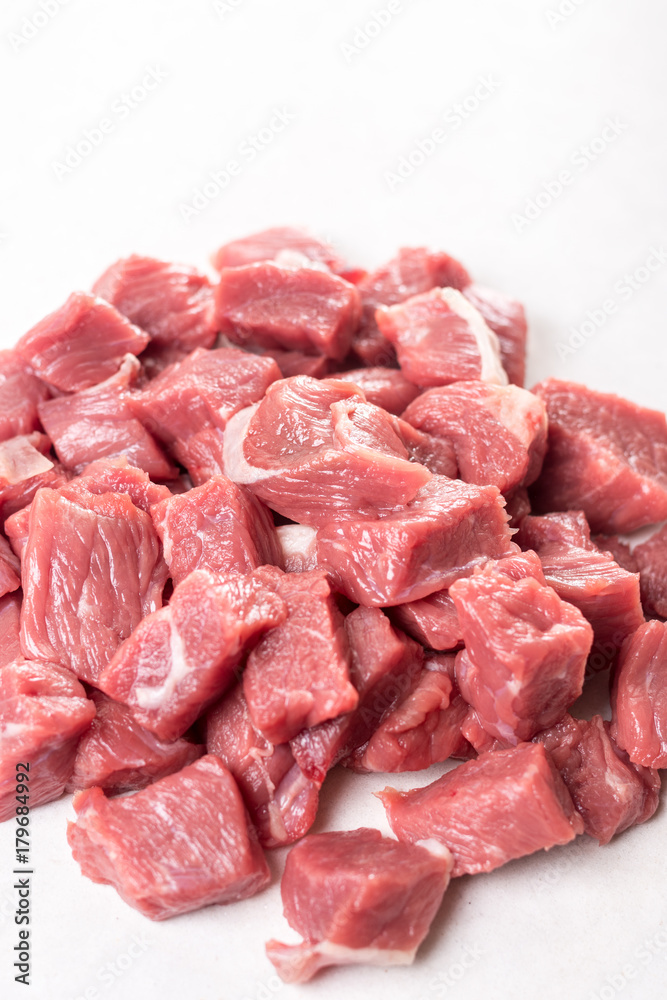 Pile of chopped raw beef steak on the white marble background table