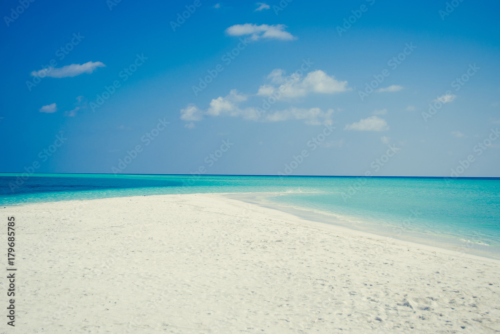 Exotic tropical beach background. Summer vacation, tourism, popular destination, luxury travel concept. Maldives. Seascape white sand, turquoise water. Paradise holiday island. Copy space. Blue sky