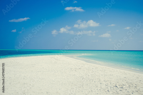 Exotic tropical beach background. Summer vacation, tourism, popular destination, luxury travel concept. Maldives. Seascape white sand, turquoise water. Paradise holiday island. Copy space. Blue sky