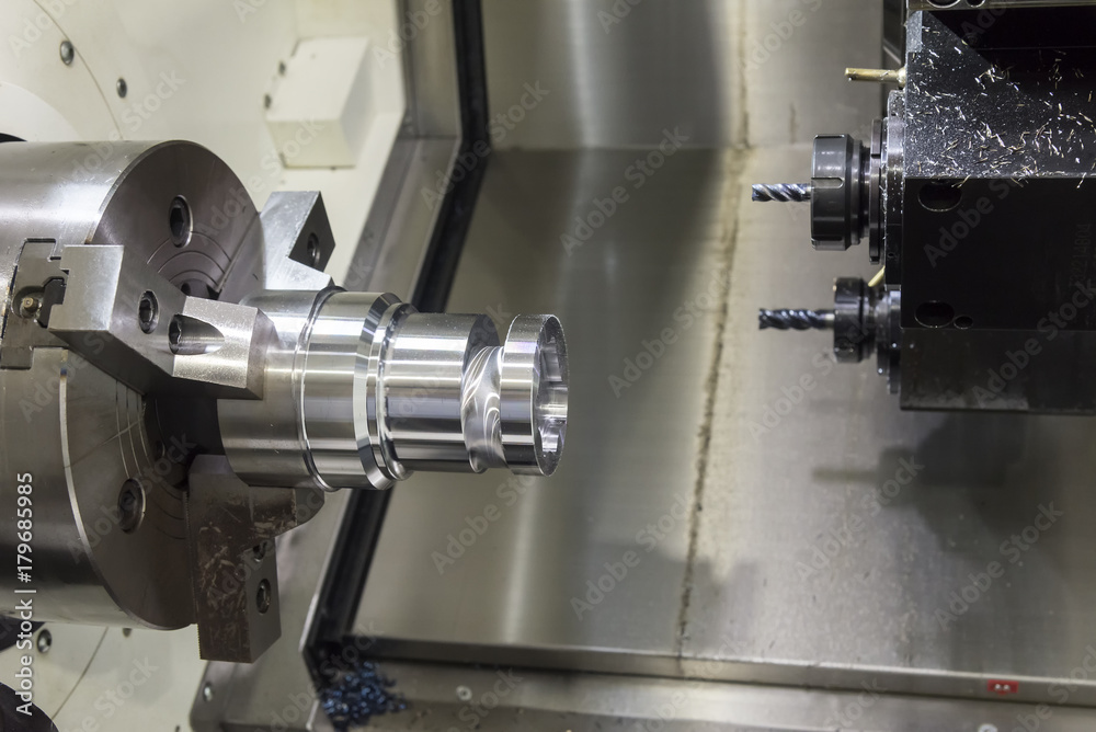 Close up of the CNC lathe jaw clamping raw material steel rod .Steel Cylinder part after turning process. Hi-precision CNC machining concept.Raw material steel rod for CNC lathe precess Close up of the CNC lathe jaw clamping raw material steel rod .Steel Cylinder part after turning process. Hi-precision CNC machining concept.Raw material steel rod for CNC lathe precess