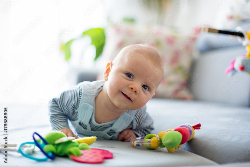 Cute baby boy, playing with toys in a sunny living room Cute baby boy, playing with toys in a sunny living room