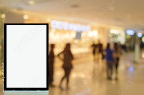 vertical light box or advertising billboard with blurred image of people shopping at shopping mall background, copy space for text or media content, advertisement, commercial and marketing concept