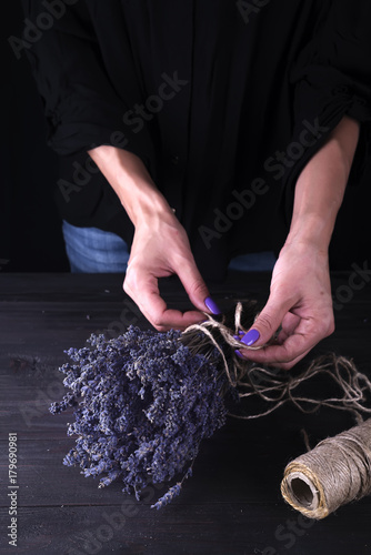 woman creating bouquet of natural lavender flowers, photo