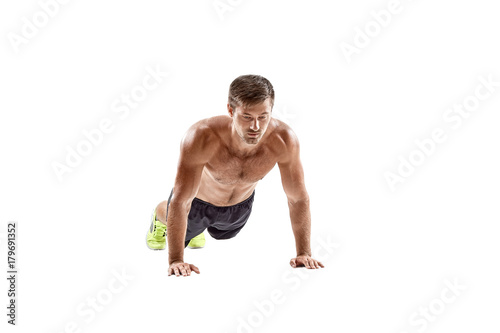Push up fitness man doing push-up bodyweight exercise on gym floor. Athlete working out chest muscles strength training indoors