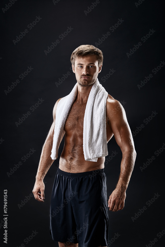 Portrait of a fitness man with towel on shoulders looking away. Happy young man relaxing after training. Portrait of a fitness man with towel on shoulders looking away. Happy young man relaxing after training.
