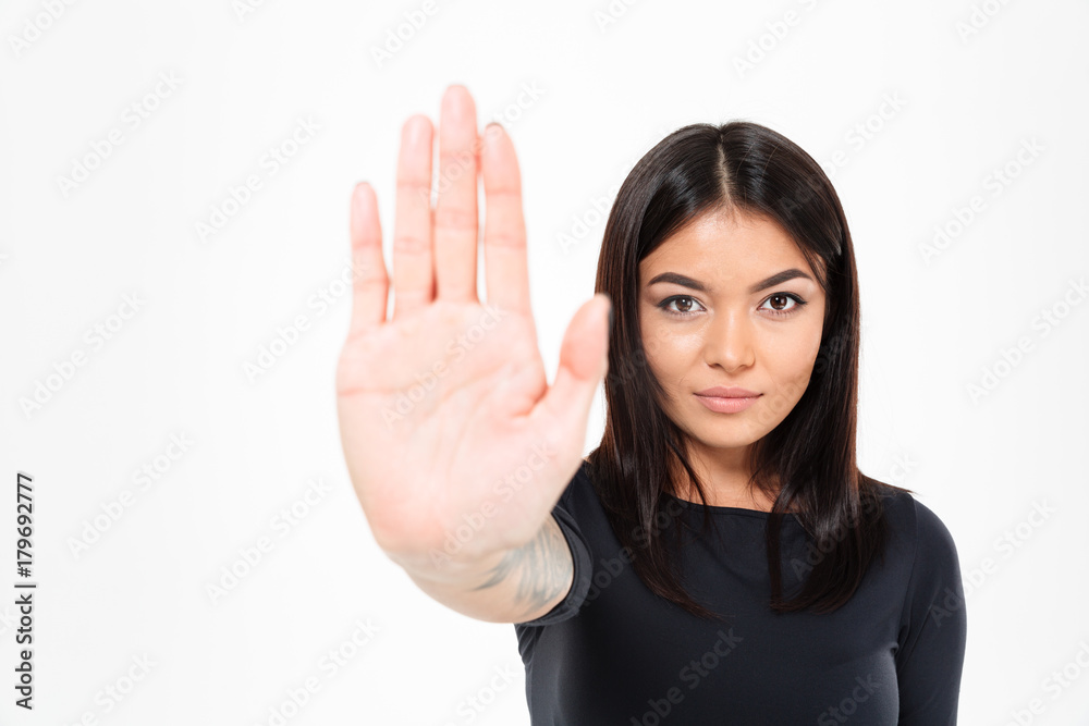 Concentrated serious young asian lady showing stop gesture Concentrated serious young asian lady showing stop gesture