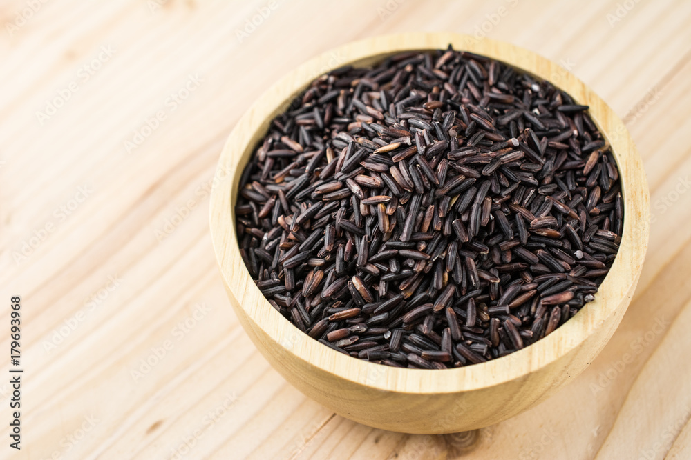 Close-up brown rice or riceberry organic food in bowl healthy on wood texture Close-up brown rice or riceberry organic food in bowl healthy on wood texture
