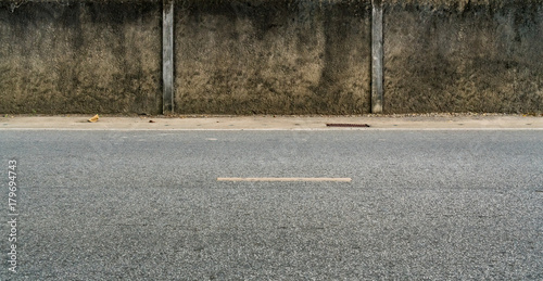 Asphalt road and concrete fence with blue sky