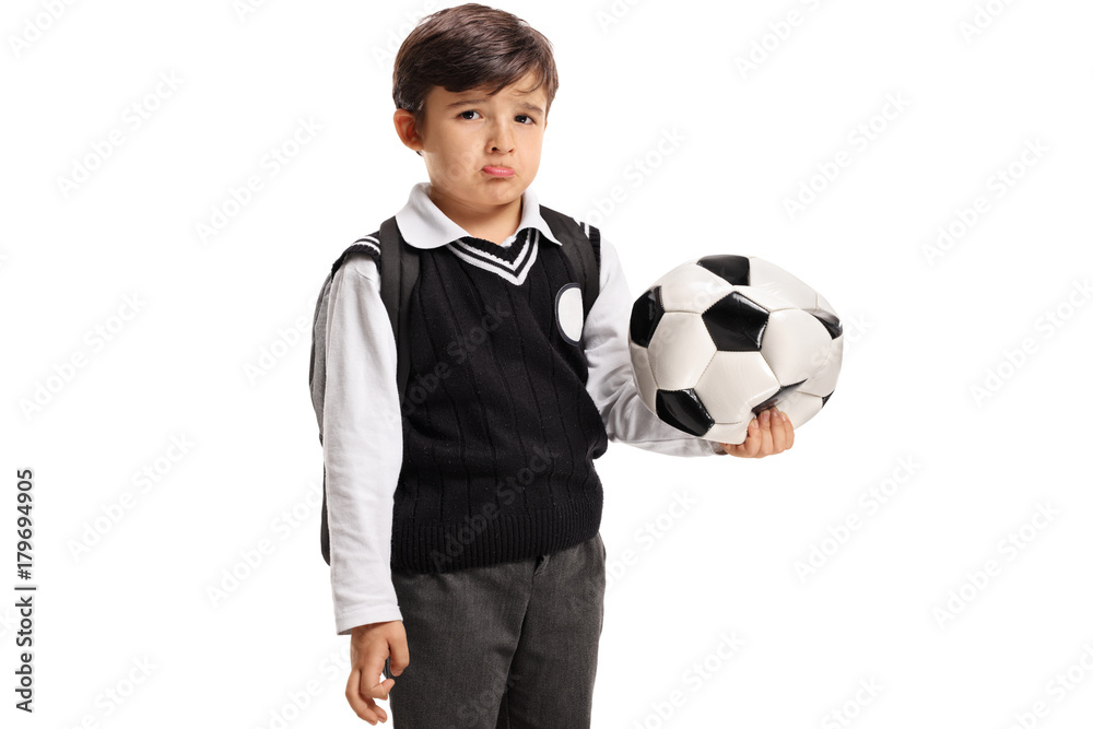 Disappointed little schoolboy with a deflated football