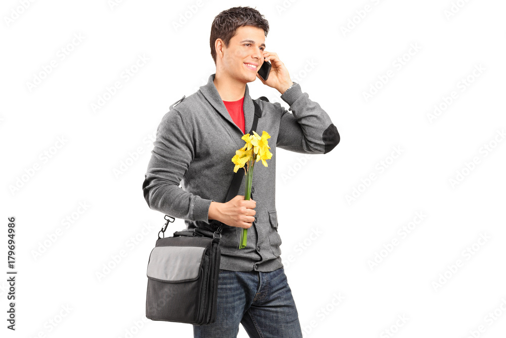 Young man holding yellow tulips and talking on a phone Young man holding yellow tulips and talking on a phone