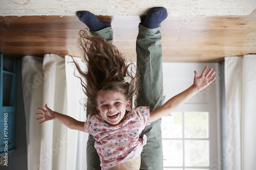 Flipped shot of girl being held upside down by her dad