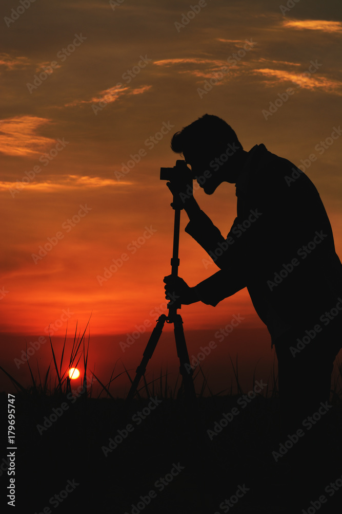 Silhouette man take photo on sunset.