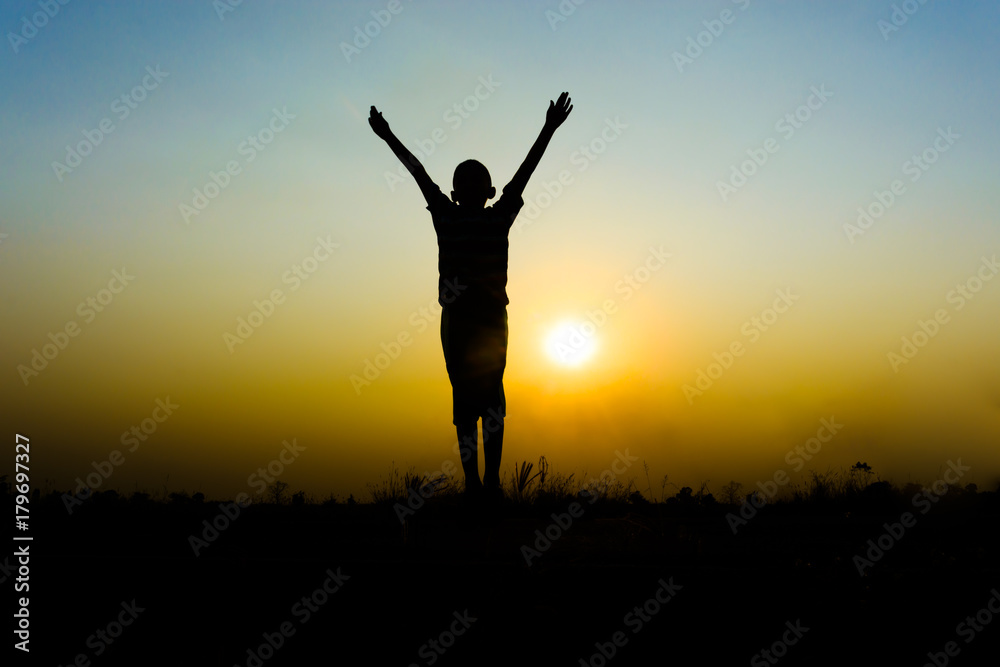 Silhouette of  boy jumping on sunset background