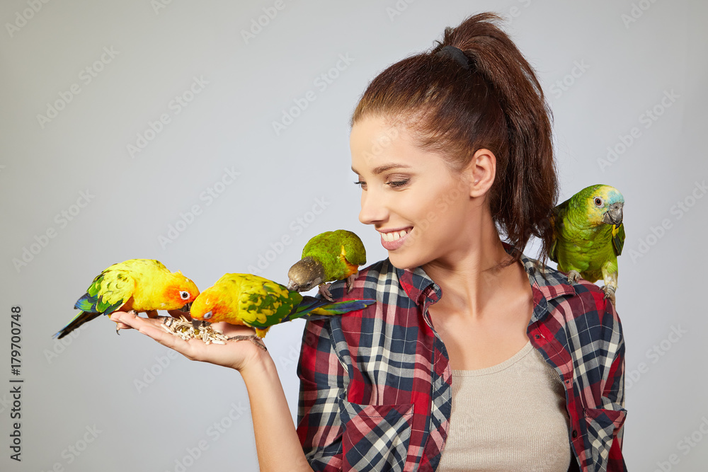 Naklejka premium Woman feeding parrots. isolated shoot