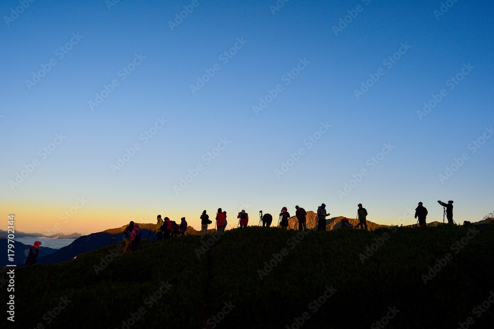 Taiwan, Hehuan mountain - October 21th. 2017:silhouette of 

photographer on top of mountain at sunset background
