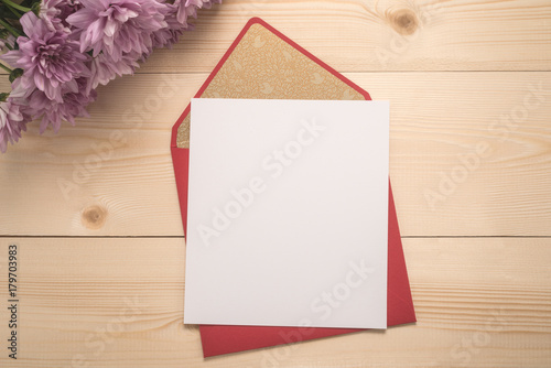 Red envelope and  flowers on wooden background  	