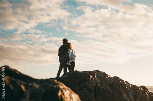Young couple holding each other on beach at sunset