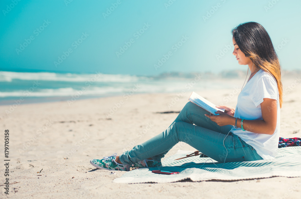Young woman reading on sandy beach Young woman reading on sandy beach